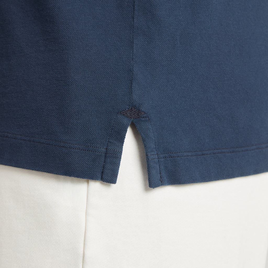Polo uomo in micro piquet blu scuro con spacchetti laterali e cuciture precise, tessuto tinta in capo