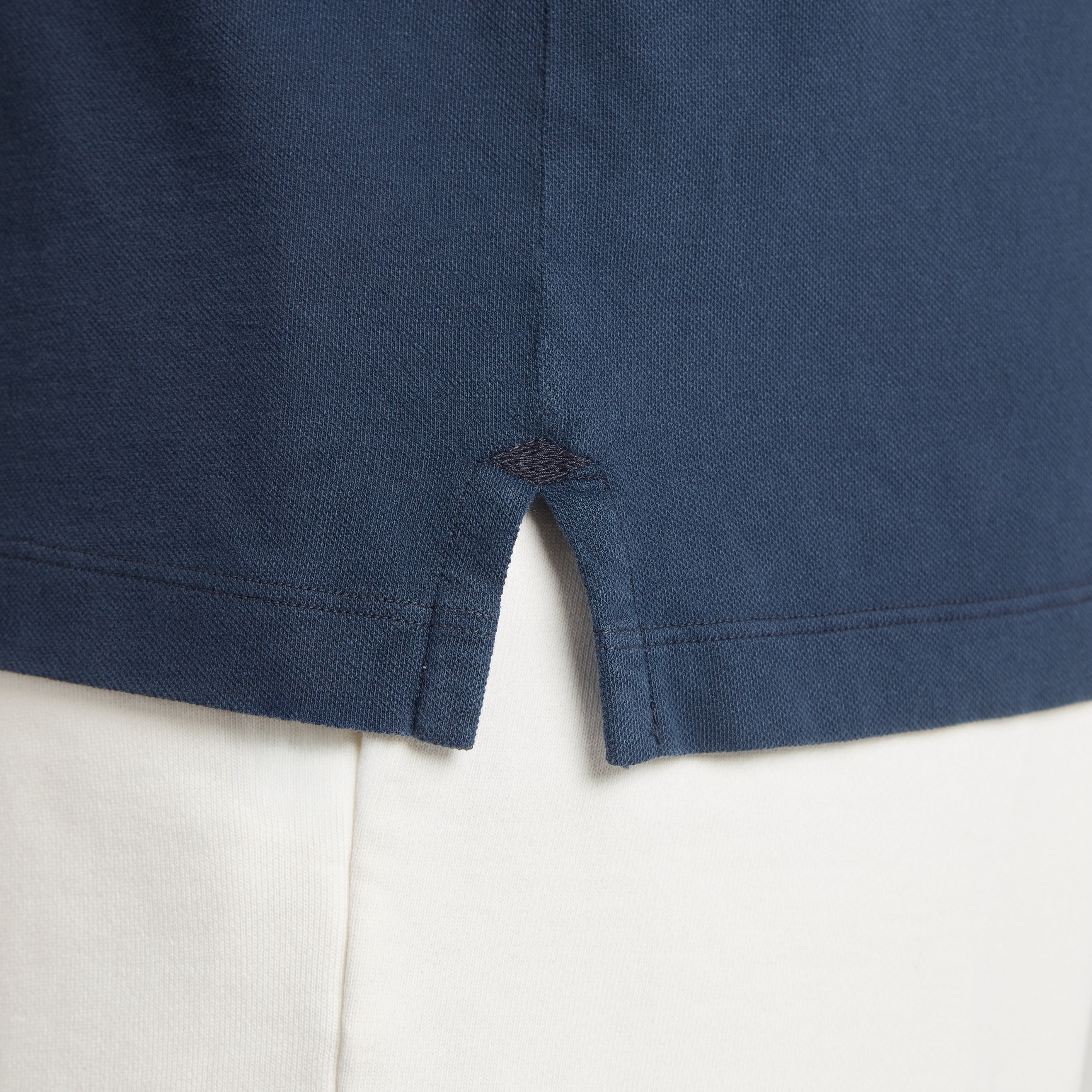 Polo uomo in micro piquet blu scuro con spacchetti laterali e cuciture precise, tessuto tinta in capo