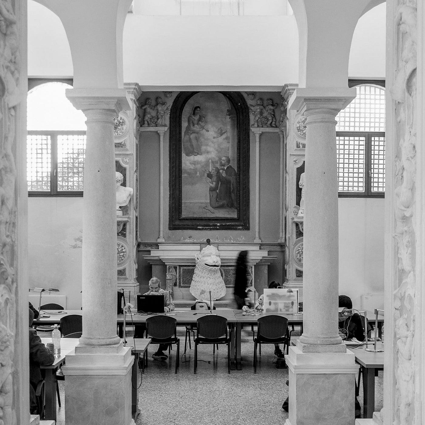 Spazio creativo Venezia con colonne, affresco e persone al lavoro in un ambiente storico